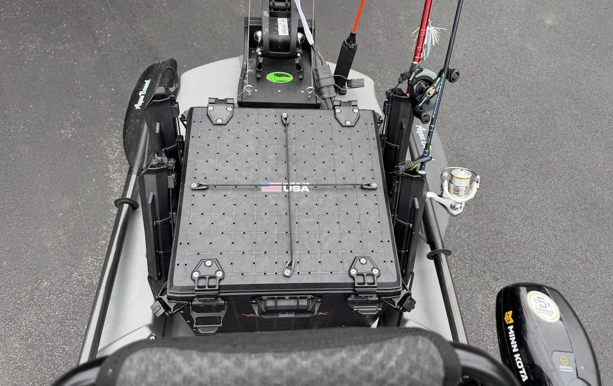 Two-piece kayak paddle stored in quick-release positions behind the seat of a fishing kayak