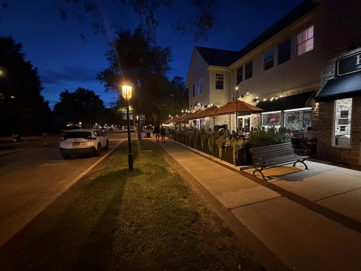 Third Street in Geneva, Illinois, just after sunset with streetlights and restaurant windows illuminated