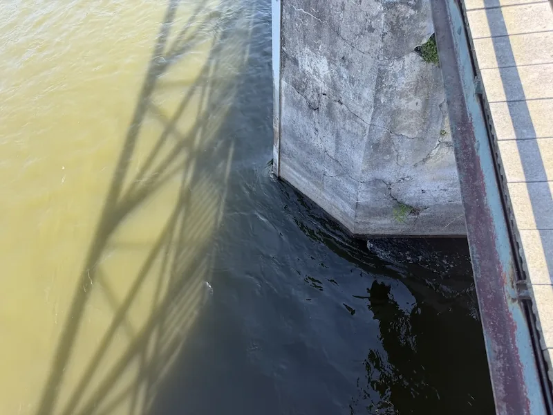 Top-down view of Fox River current meeting a bridge pylon in St. Charles