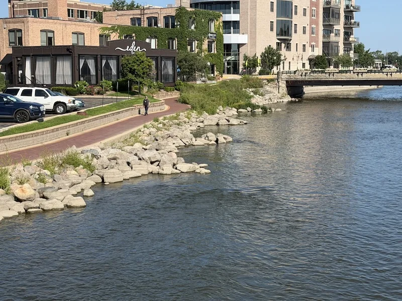Rock and shallow structure visible beside the Fox River near a bridge