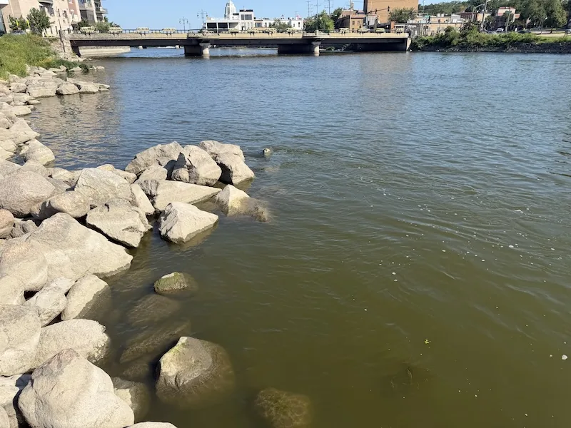 Fox River rock structure and moving water near a bridge in St. Charles